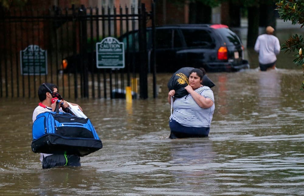 Residentes de Baton Rouge (Louisiana) andan por las calles inundadas de la ciudad.