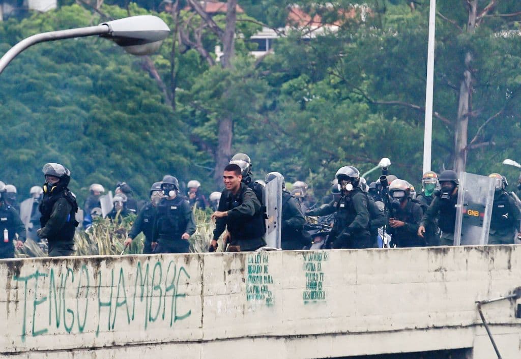 Un soldado de la GN empuña un arma durante la represión a una protesta en Caracas.