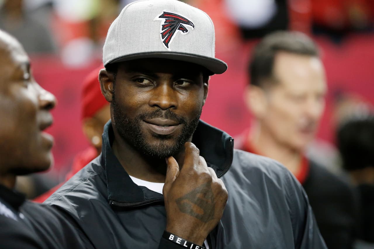 FILE - In this Jan. 1, 2017, file photo, former Atlanta Falcons quarterback Michael Vick stands on the sidelines before NFL football game between the Falcons and the New Orleans Saints in Atlanta. Vick told Fox Sports 1 Monday, July 17, 2017, that former San Francisco 49ers quarterback Colin Kaepernick should get a haircut in order to "try to be more presentable" as he searches for another NFL job. (AP Photo/John Bazemore, File)