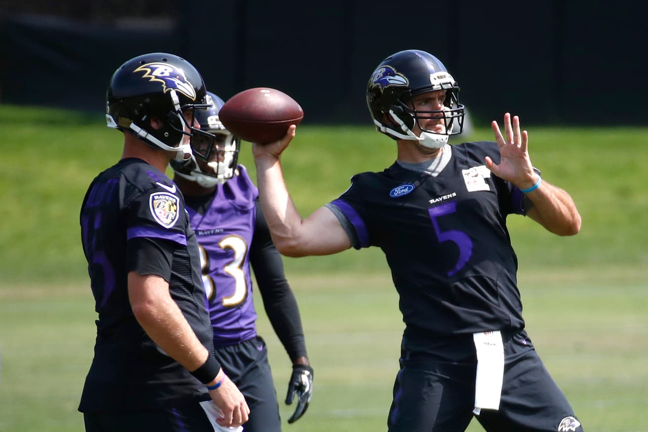 Baltimore Ravens quarterback Joe Flacco, right, throws a pass as teammates watch during NFL football minicamp at the team's practice facility in Owings Mills, Md., Thursday, June 15, 2017. (AP Photo/Patrick Semansky)