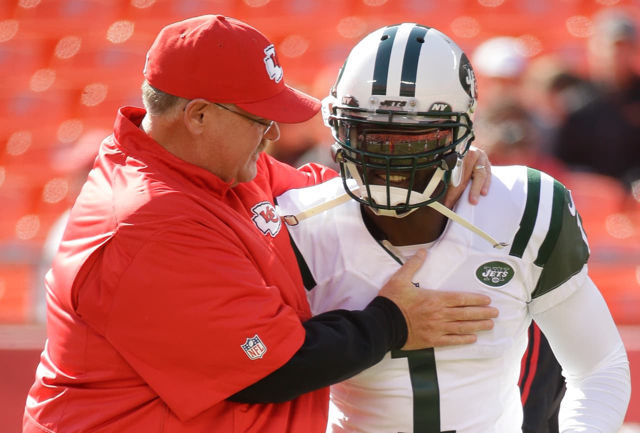 Kansas City Chiefs head coach Andy Reid meets with New York Jets quarterback Michael Vick (1) before an NFL football game in Kansas City, Mo., Sunday, Nov. 2, 2014. (AP Photo/Charlie Riedel)