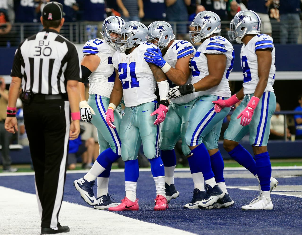 Back judge Todd Prukop (30) watches as Dallas Cowboys' Ezekiel Elliott, celebrates his touchdown run with Zack Martin (70), Travis Frederick (72), Ronald Leary (65) and Brice Butler (19) in the first half of an NFL football game against the Cincinnati Bengals on Sunday, Oct. 9, 2016, in Arlington, Texas. (AP Photo/Ron Jenkins)