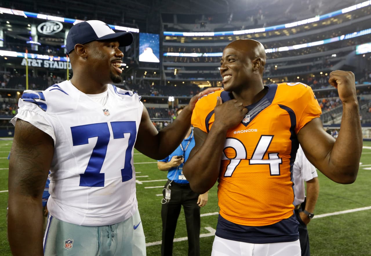 Dallas Cowboys' Tyron Smith (77) talks with former teammate Denver Broncos' DeMarcus Ware (94) following their NFL preseason football game, Thursday, Aug. 28. 2014, in Arlington, Texas. The Broncos won 27-3. (AP Photo/LM Otero)