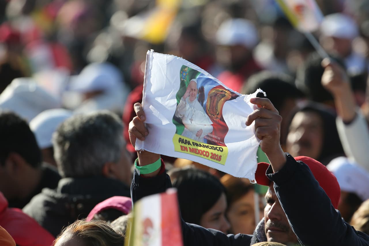 Este hombre levanta una bandera con el rostro de Francisco acompañado de la Virgen de Guadalupe.