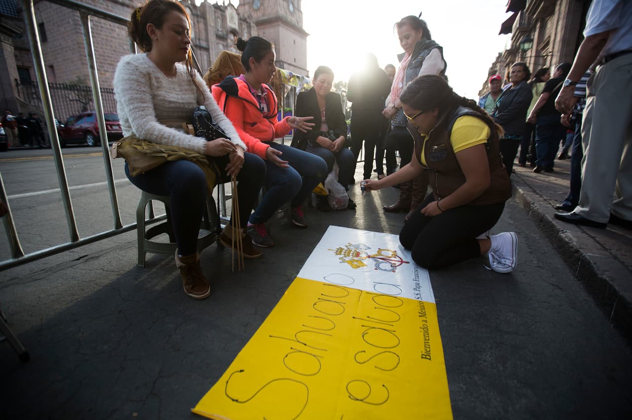 Este grupo de jóvenes preparan un cártel de bienvenida para Francisco.