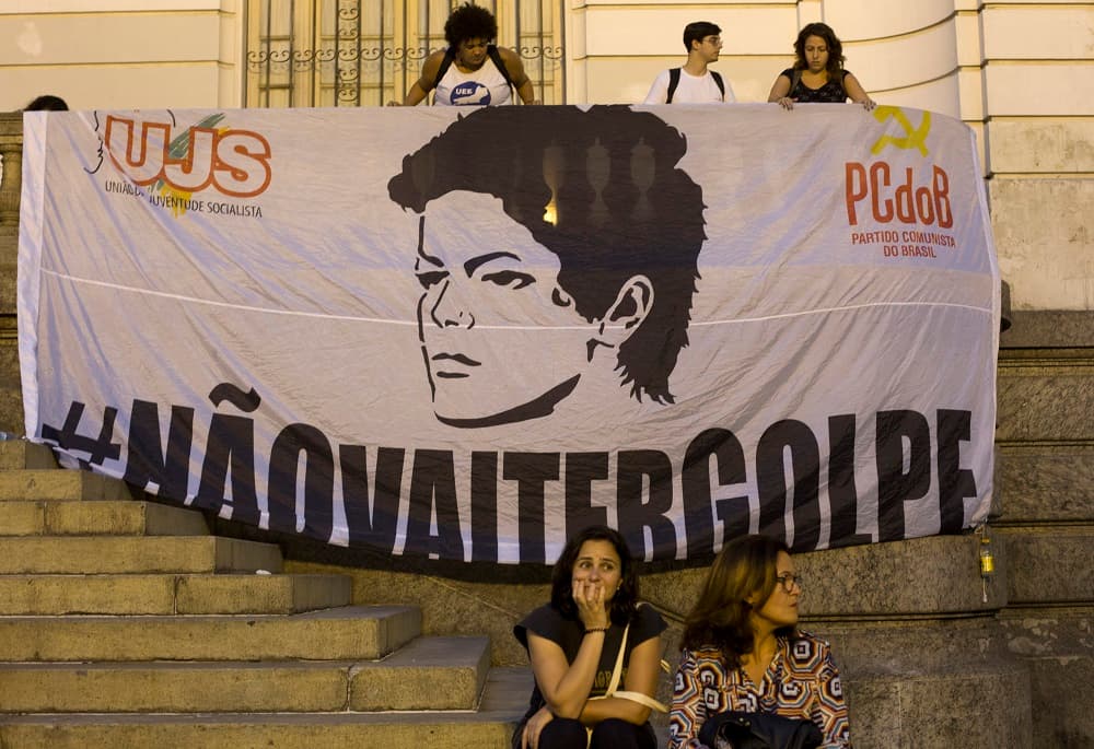 Manifestantes partidarios del gobierno de Brasil se reúnen junto a una pancarta que muestra la cara de la presidenta, Dilma Rousseff, y en la que se puede leer "No habrá golpe de estado" (en portugués).