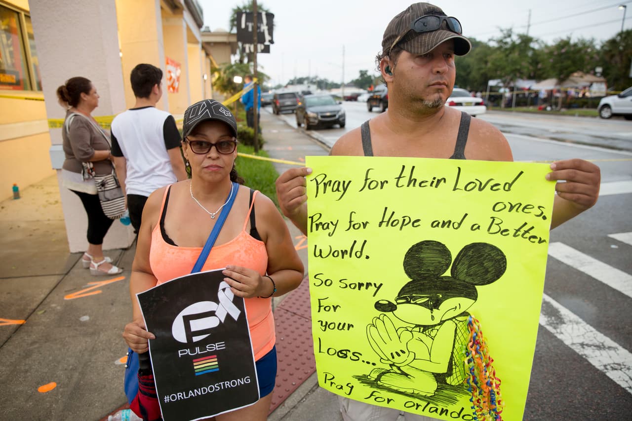 Amigos y familiares de las víctimas se acercan al cordón policial con mensajes de apoyo.