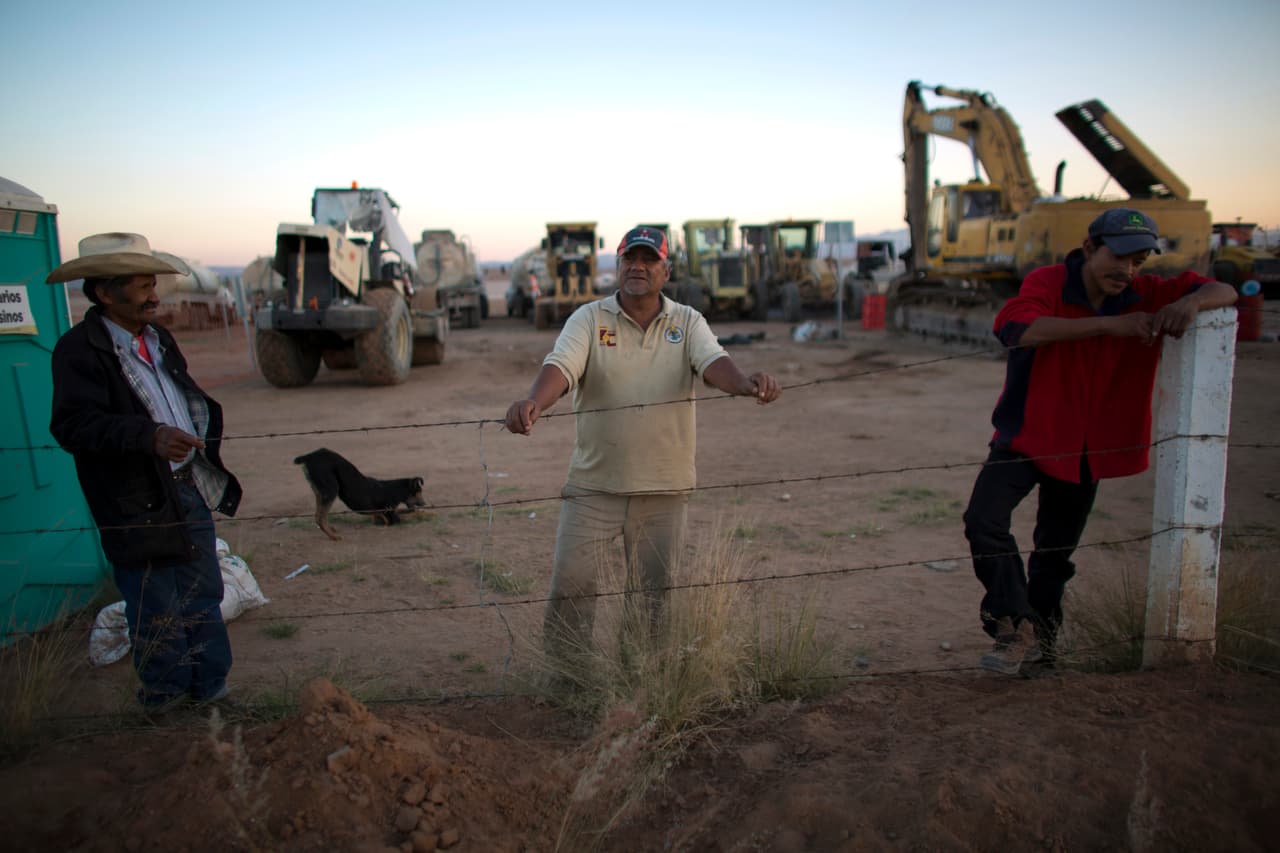 José Guadalupe González (izquierda) y otros guardias de seguridad junto al equipo restante de maquinaria pesada en el sitio donde se iba a construir una fábrica de Ford en Villa de Reyes, cerca de la ciudad de San Luis Potosí, México, el miércoles 4 de enero de 2017.