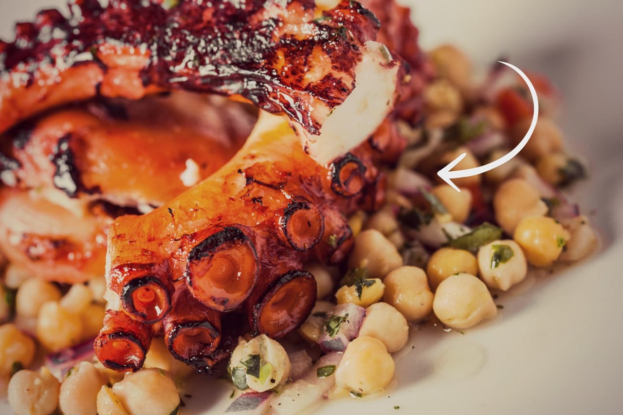 Pulpo a la parrilla servido con garbanzos.