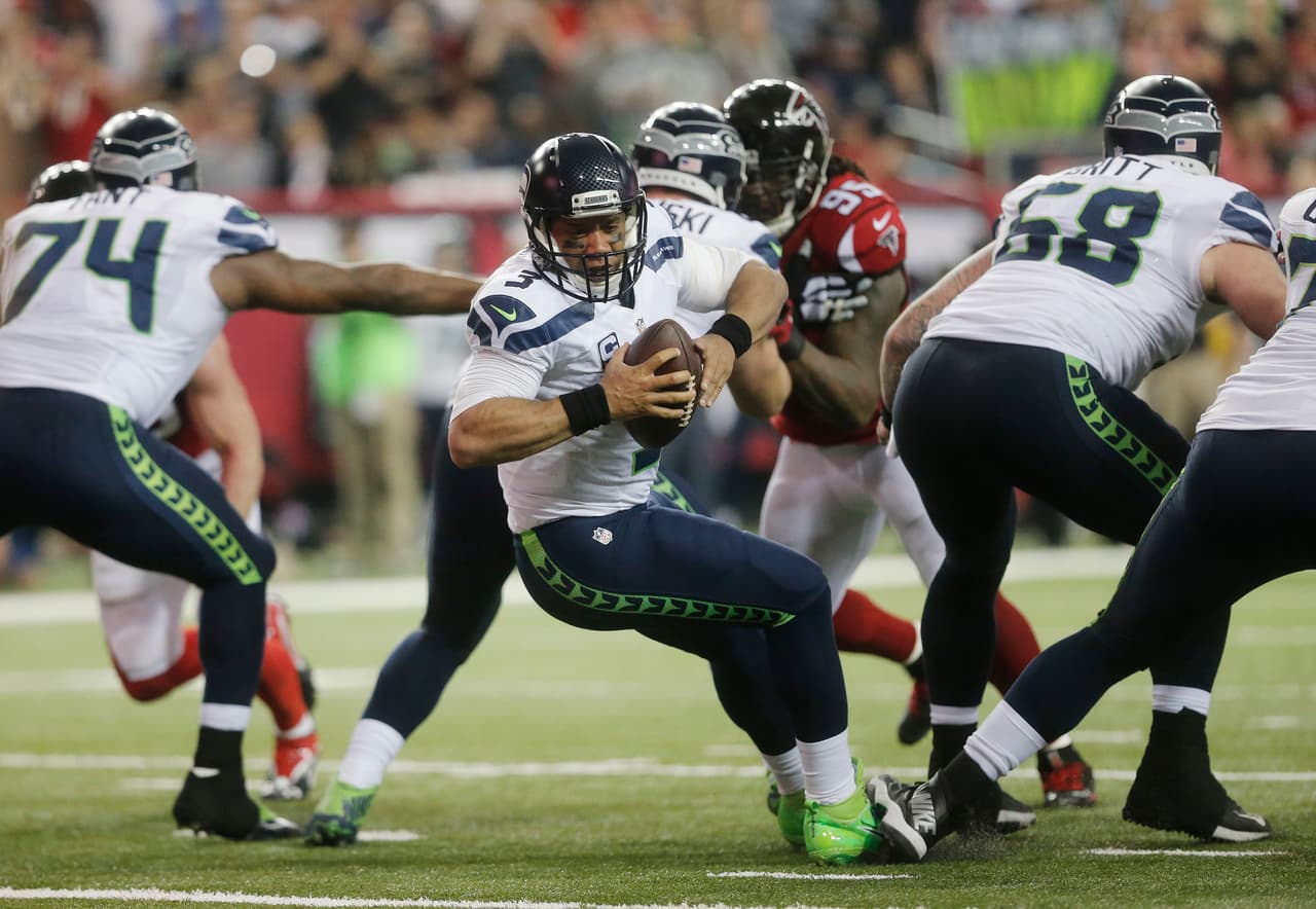 Seattle Seahawks quarterback Russell Wilson (3) trips at the line of scrimmage against the Atlanta Falcons during the first half of an NFL football divisional football game, Saturday, Jan. 14, 2017, in Atlanta. (AP Photo/John Bazemore)