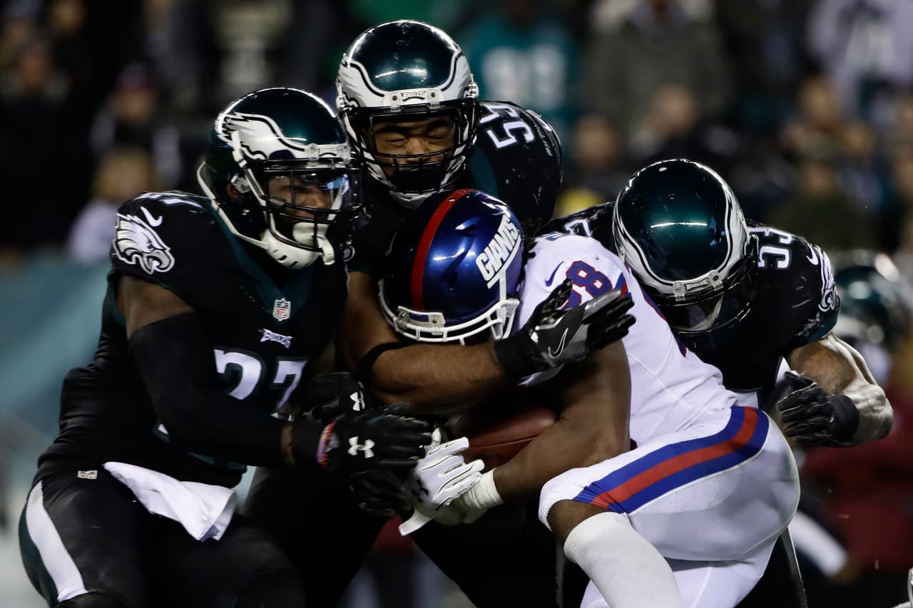 Philadelphia Eagles' Malcolm Jenkins (27), Brandon Graham (55) and Nigel Bradham (53) tackle New York Giants' Paul Perkins (28) during the second half of an NFL football game, Thursday, Dec. 22, 2016, in Philadelphia. (AP Photo/Matt Rourke)
