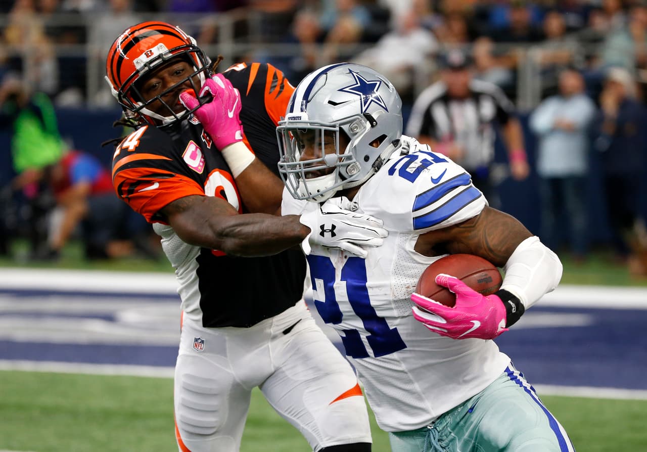 Dallas Cowboys running back Ezekiel Elliott (21) fights off a tackle attempt by Cincinnati Bengals cornerback Adam Jones (24) in the first half of an NFL football game, Sunday, Oct. 9, 2016, in Arlington, Texas. (AP Photo/Ron Jenkins)