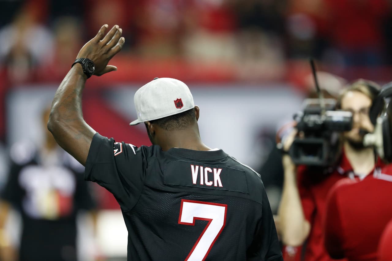 Former Atlanta Falcons player Michael Vick waves to the crowd during halftime of an NFL football game between the Atlanta Falcons and the New Orleans Saints, Sunday, Jan. 1, 2017, in Atlanta. (AP Photo/John Bazemore)