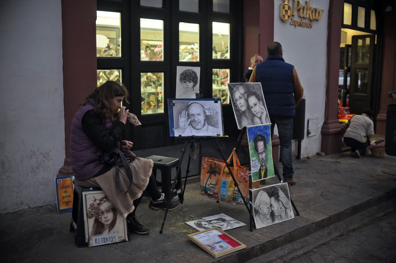 Esta mujer vende pinturas, hechas a mano, del papa Francisco.