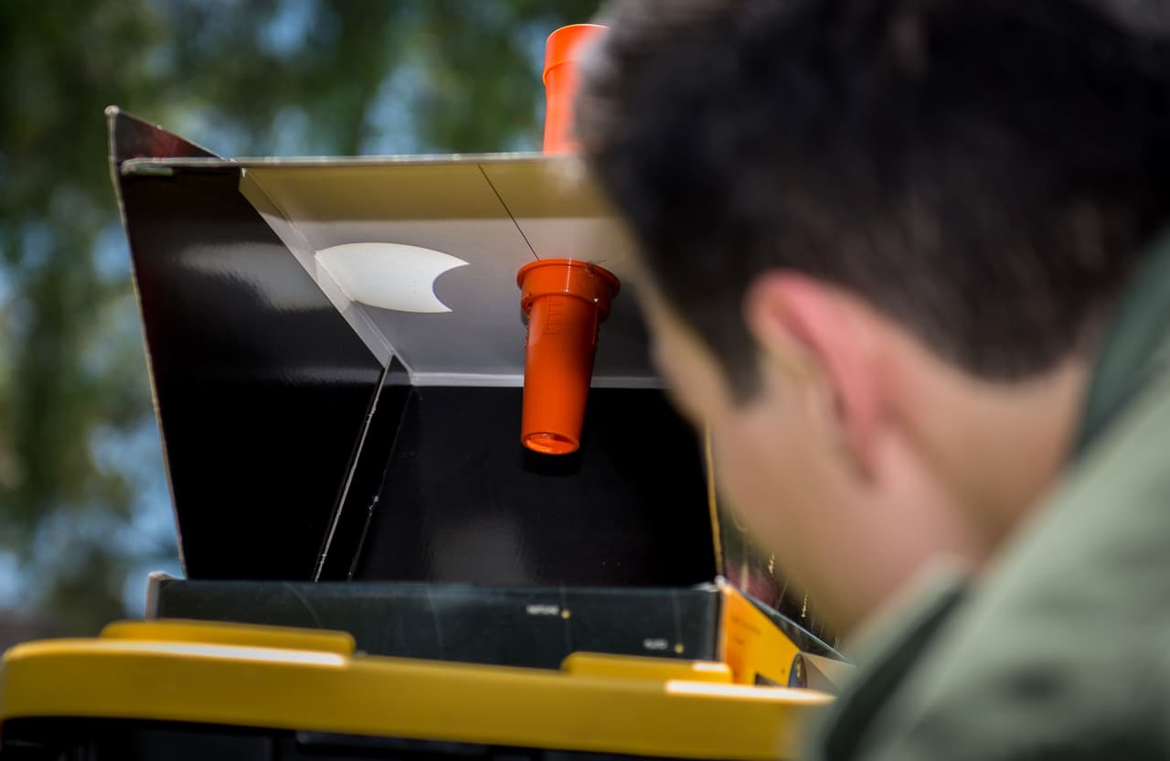 Un hombre mira una caja negra instalada para el público que muestra el reflejo del eclipse solar parcial, en el Instituto de Astronomía de la Universidad Nacional Autónoma de México en Ciudad de México.
<br>