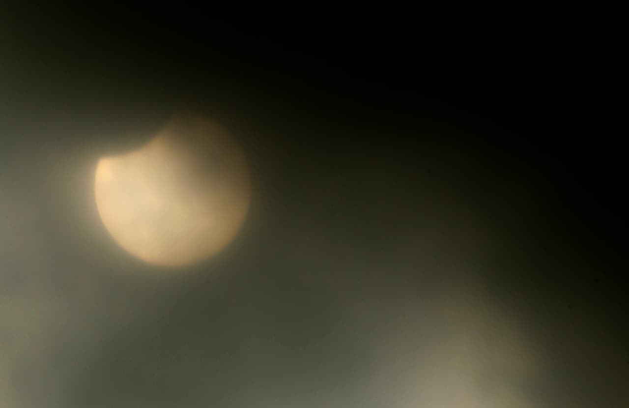 La Luna en su trayectoria por delante del Sol durante el eclipse parcial. Por momentos el cielo estuvo nublado y así se vio en Ciudad de México (México).