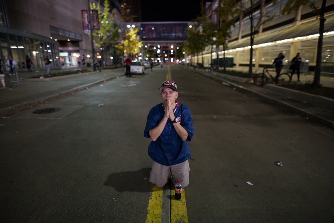 William Burgos de Cleveland reza en la calle fuera del Progressive Field durante el noveno inning.