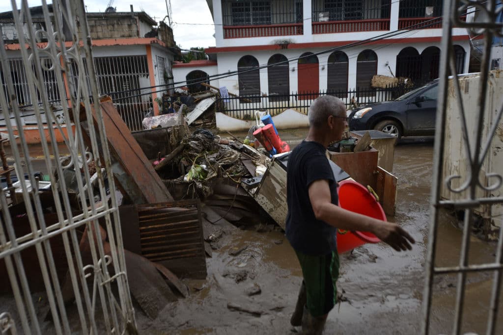 Víctor Otero sale de su casa inundada en el municipio de Toa Baja, tras el paso del huracán María por Puerto Rico.