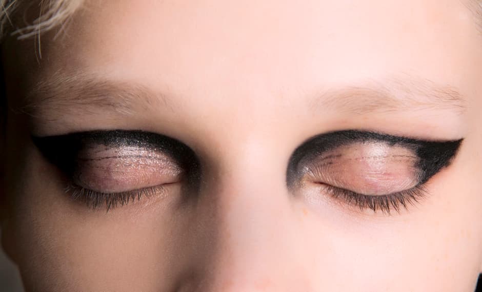 Este maquillaje tiene un trazo gráfico que se inspira en el delineado estilo cat eye. Pero para lograr esta propuesta no debes de tocar la línea de las pestañas. El trazo nace del lagrimal y va al rabillo de los ojos, pero por la parte superior del párpado. Puedes lograr este efecto con ayuda de un lápiz delineador negro. Difumina ligeramente la mancha que se forma sobre los pliegues.
<br>