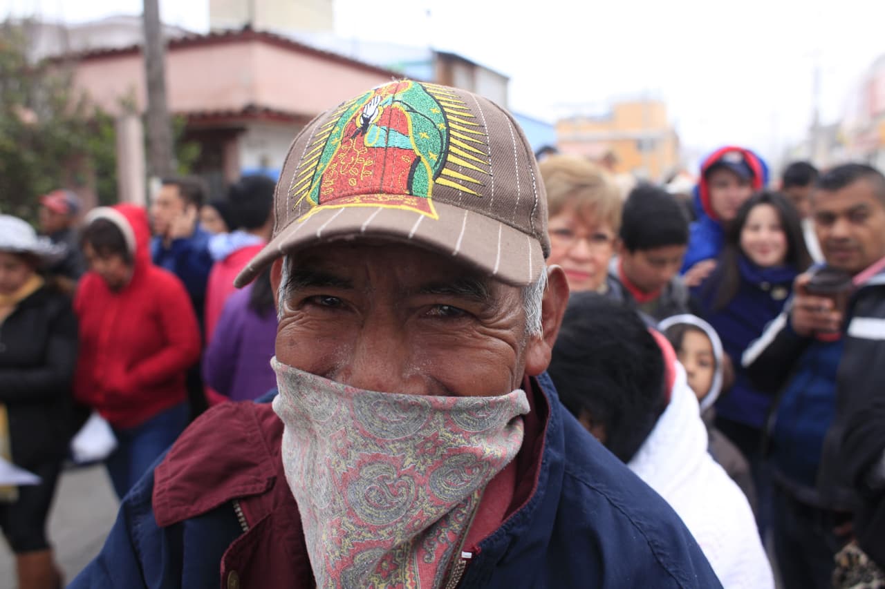 Este hombre sostiene en su caberza una gorra con la imagen de la Virgen de Guadalupe.