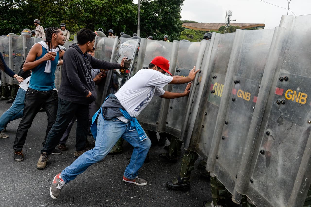 Manifestantes opositores al gobierno de Nicolás Maduro, al momento de llegar a la barrera impuesta por la policía antidisturbios de Venezuela, que interrumpió el paso de la marcha opositora hacia el Consejo Nacional Electoral.