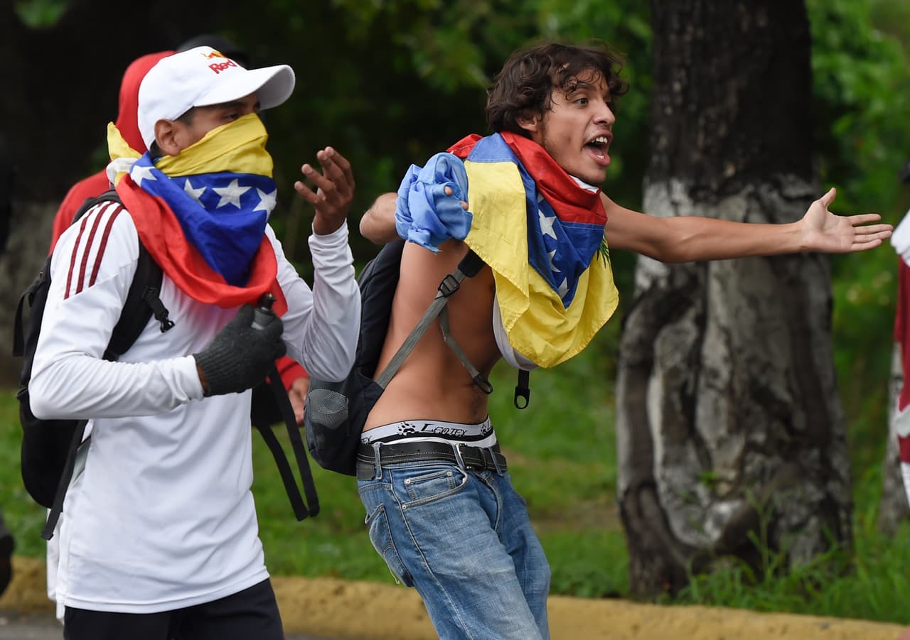 Manifestantes jóvenes enfrentados a las fuerzas antimotines del estado.