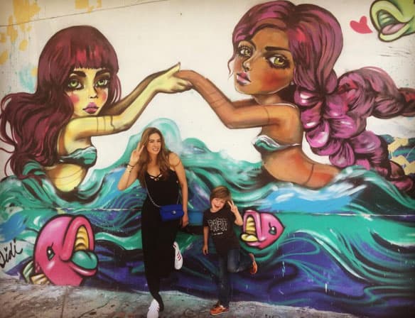 Posando con un mural de sirenas.