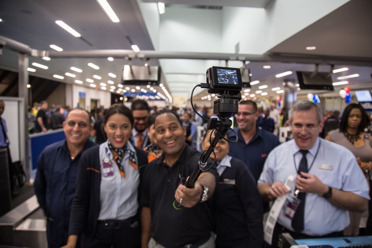Tony Dandrades de Univision Noticias posa sonriente junto al equipo de JetBlue en la zona de embarque del aeropuerto de Fort Lauderdale. El vuelo inaugural de la compañía a Santa Clara en Cuba es el primero de una aerolínea comercial norteamericana en más de 50 años.
<br>