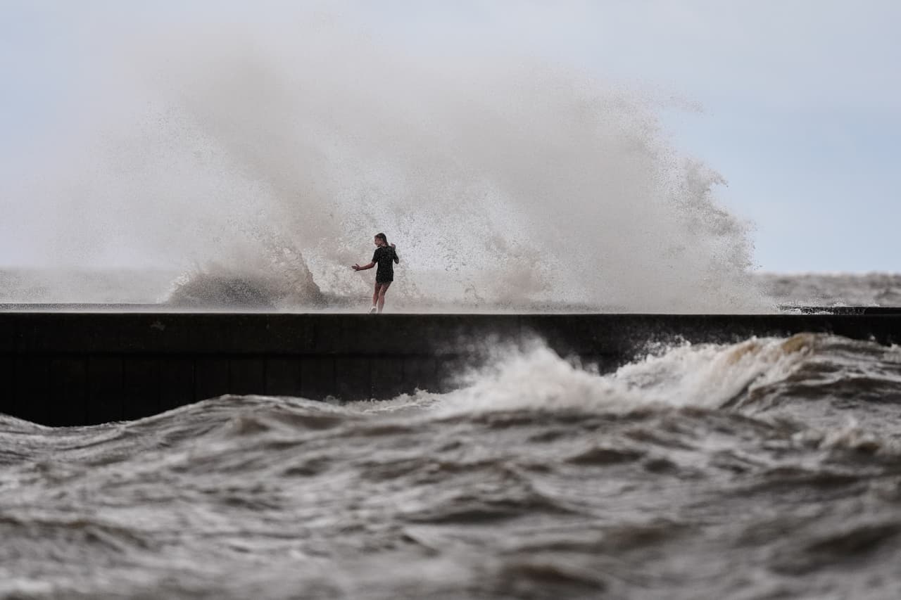Unos niños juegan cerca de las olas que rompen en el muelle de West End, en el lago Pontchartrain, mientras la tormenta tropical Bertha se acerca a la costa de Luisiana el miércoles 22 de julio de 2026, en Nueva Orleans. (Foto AP/Gerald Herbert)