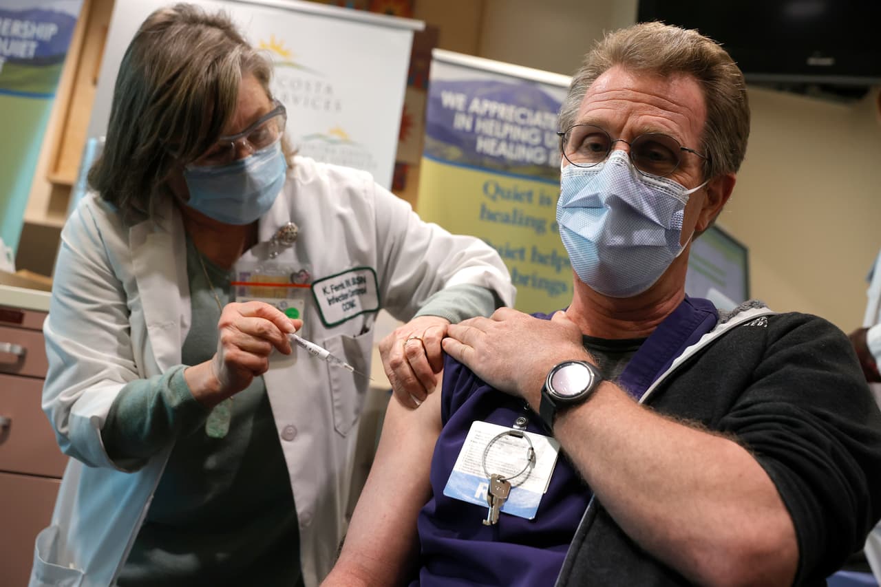 Kathy Ferris (Izquierda) administra una vacuna Pfizer covid-19 al trabajador de atención médica de primera línea Matthew Brenner en Martinez, California.