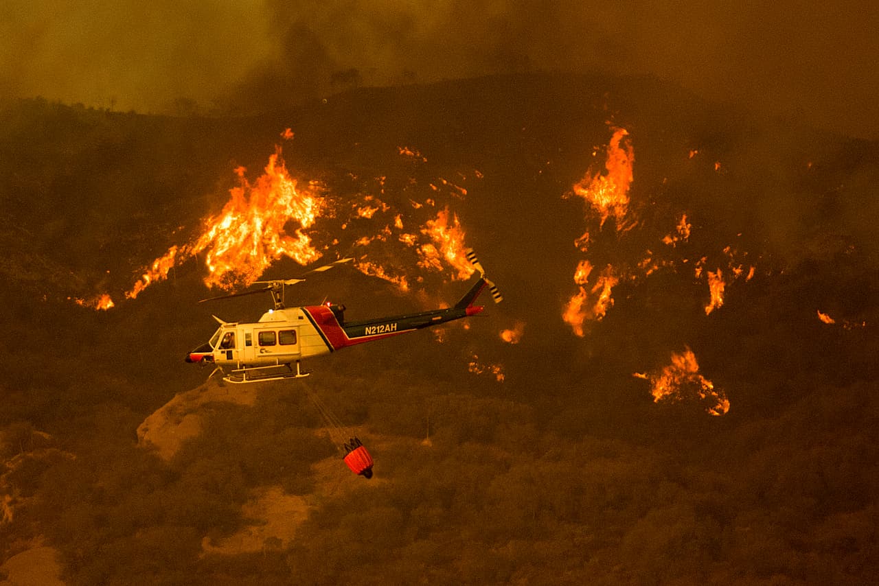 Los bomberos, con la ayuda de aeronaves que vierten agua, salvaron varias viviendas el fin de semana mientras las impredecibles ráfagas de viento reavivaron el fuego al pie de las colinas de una zona al noroeste de Los Ángeles en la que no se habían registrado incendios en décadas.