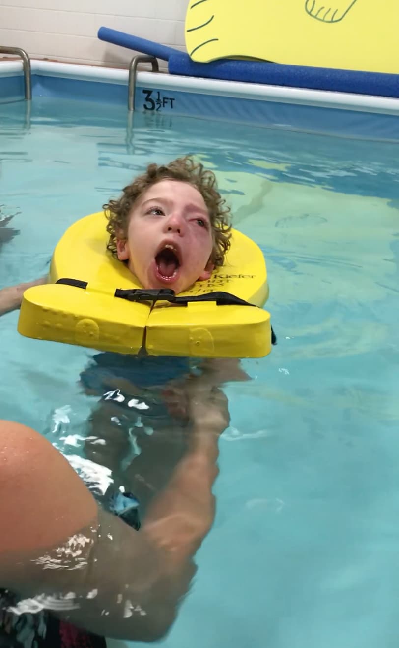 <b>Pez en el agua. </b>En el agua tibia, Alejando pareciera liberarse de todos los impedimentos que tiene y mueve sus piernas y brazos como nunca. Con la ayuda de un chaleco salvavidas especial o con un flotador que mantiene su cabeza fuera del agua, él es feliz como un pez nadando para mejorar tono muscular, coordinación y resistencia. Dos veces a la semana, durante la primavera y el verano, Alejandro participa en un programa intensivo de 
<a href="https://www.kidtherapy.org/services/aqua-therapy-2/"><u>terapia acuática</u></a> que combina terapia física y ocupacional en el NYU Rusk Institute of Rehabilitation Medicine de Nueva York.