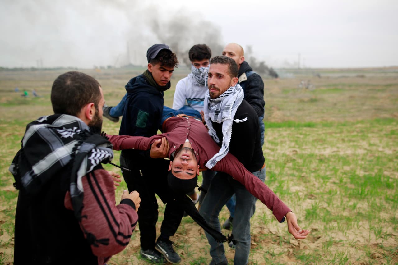 <b>Palestina protesta.</b> La decisión de Donald Trump de mudar la embajada de EEUU en Israel a Jerusalén y reconocer a esta ciudad como capital comenzó una oleada intensa de protestas en varias ciudades palestinas. La medida, que no ha sido respaldada por la comunidad internacional, fue aplaudida por el primer ministro israelí Benjamín Netanyahu. En la fotografía, manifestantes palestinos cargan a un compañero herido en las refriegas contra soldados israelíes en Gaza. 22 de diciembre de 2017.