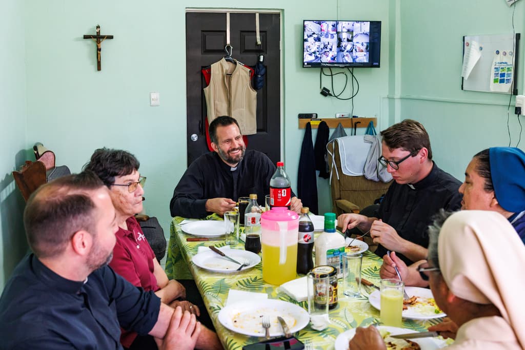El reverendo Brian Strassburger come con otros jesuitas y monjas en la Casa del Migrante el jueves 19 de marzo de 2026, en Reynosa, México. (AP Foto/Michael Gonzalez)