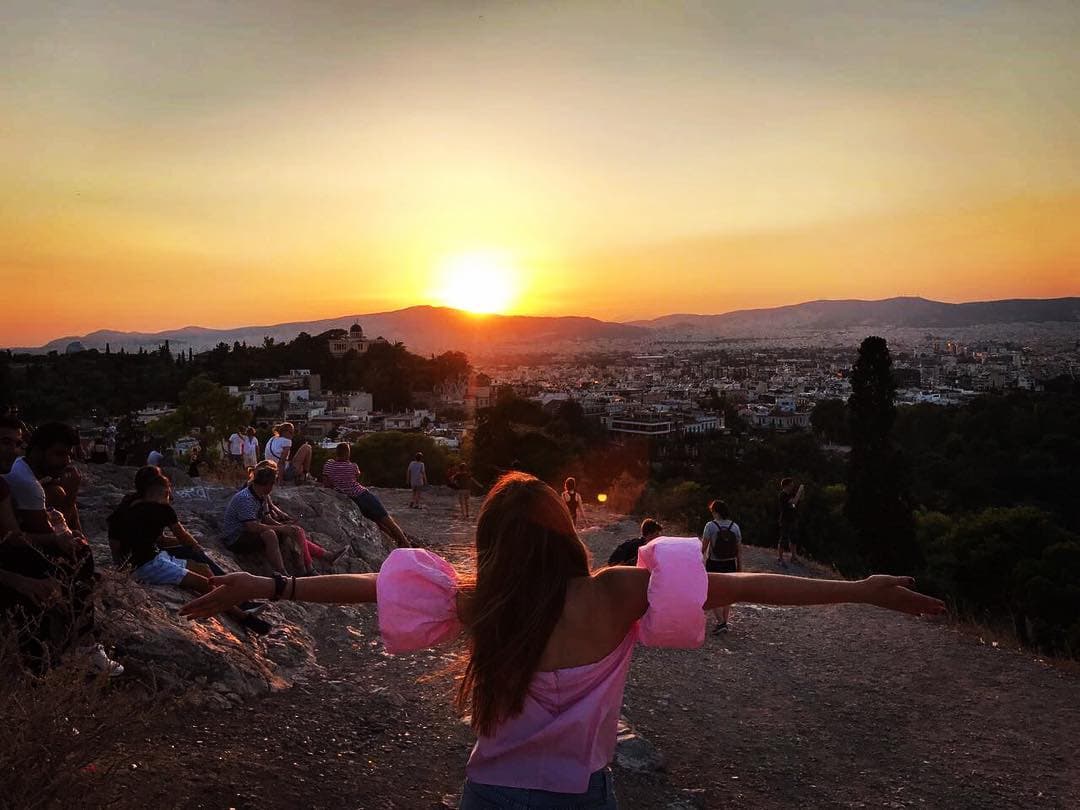 "Cada verano tiene su historia..." es la frase que acompaña a esta espectacular imagen tomada desde lo más alto de algún punto en Atenas. La actriz se puede ver con los brazos abiertos despidiendo al inmenso sol.
