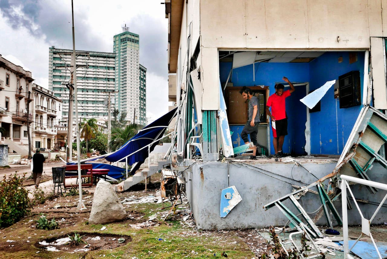 Residentes de La Habana limpian sus casas destruidas por los vientos del huracán Irma y por las inundaciones que hubo en la ciudad. En el fondo de la imagen se ve el edificio Focsa, en el barrio El Vedado. Data de los años 50 y con sus 36 pisos (en su mayoría destinados a viviendas) es uno de los edificios más visibles de la ciudad.