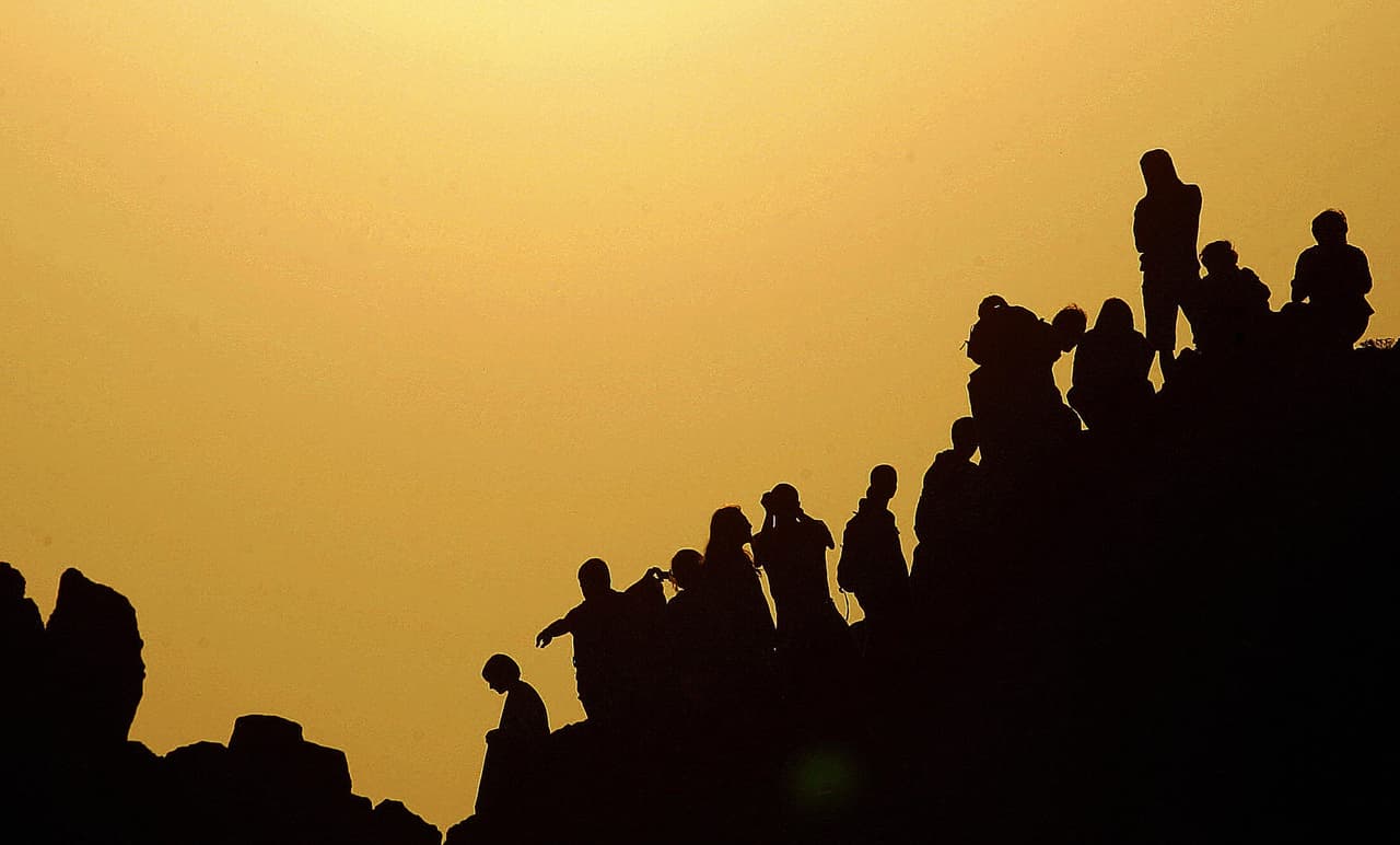 Un grupo de personas mira el sol desde el observatorio prehistórico de de Kokino, Macedonia, el día del solsticio de verano de 2007. Está clasificado por la NASA como el cuarto observatorio más antiguo del mundo y data de data de más de 4,000 años