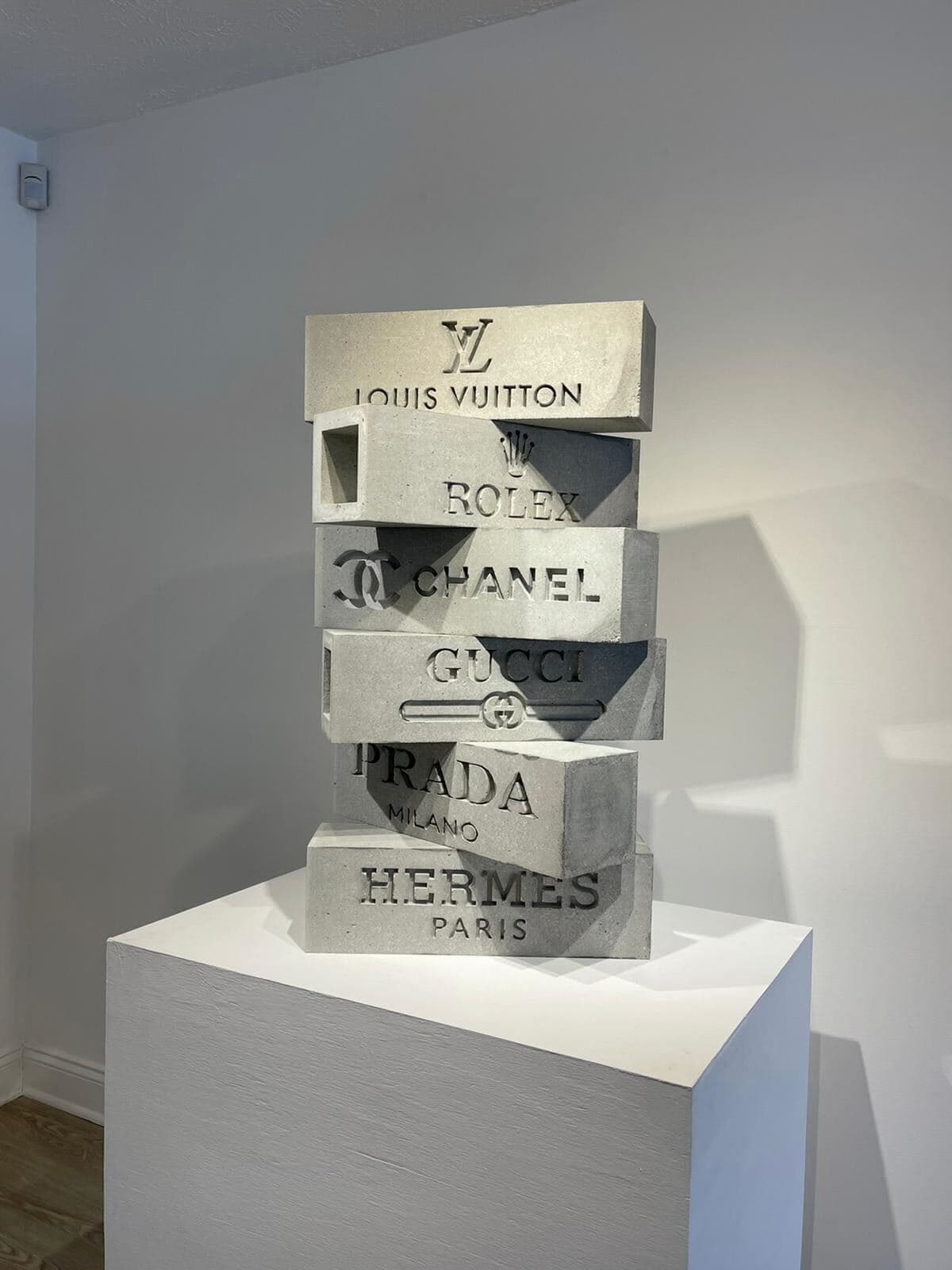 "Fashion Tower" (Torre de Moda) son seis bloques de cemento con los nombres y logos de las marcas: Louis Vuitton, Rolex, Chanel, Gucci, Prada y Hermes.