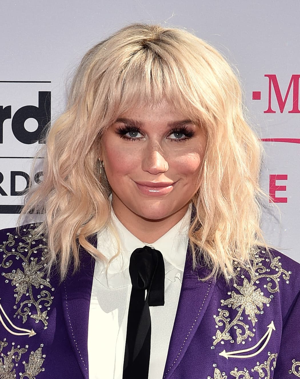 Kesha optó por aplicar unas pestañas postizas abundante y largas, pero no exageró en su maquillaje. Nos gusta que quien la maquilló uso productos ligeros en la piel que dejaron al descubierto sus atractivas pecas. La máscara de pestañas negra en las pestañas inferiores juega un papel clave en su look. El tono del lipstick nude y el acabado definitivamente le favorece.