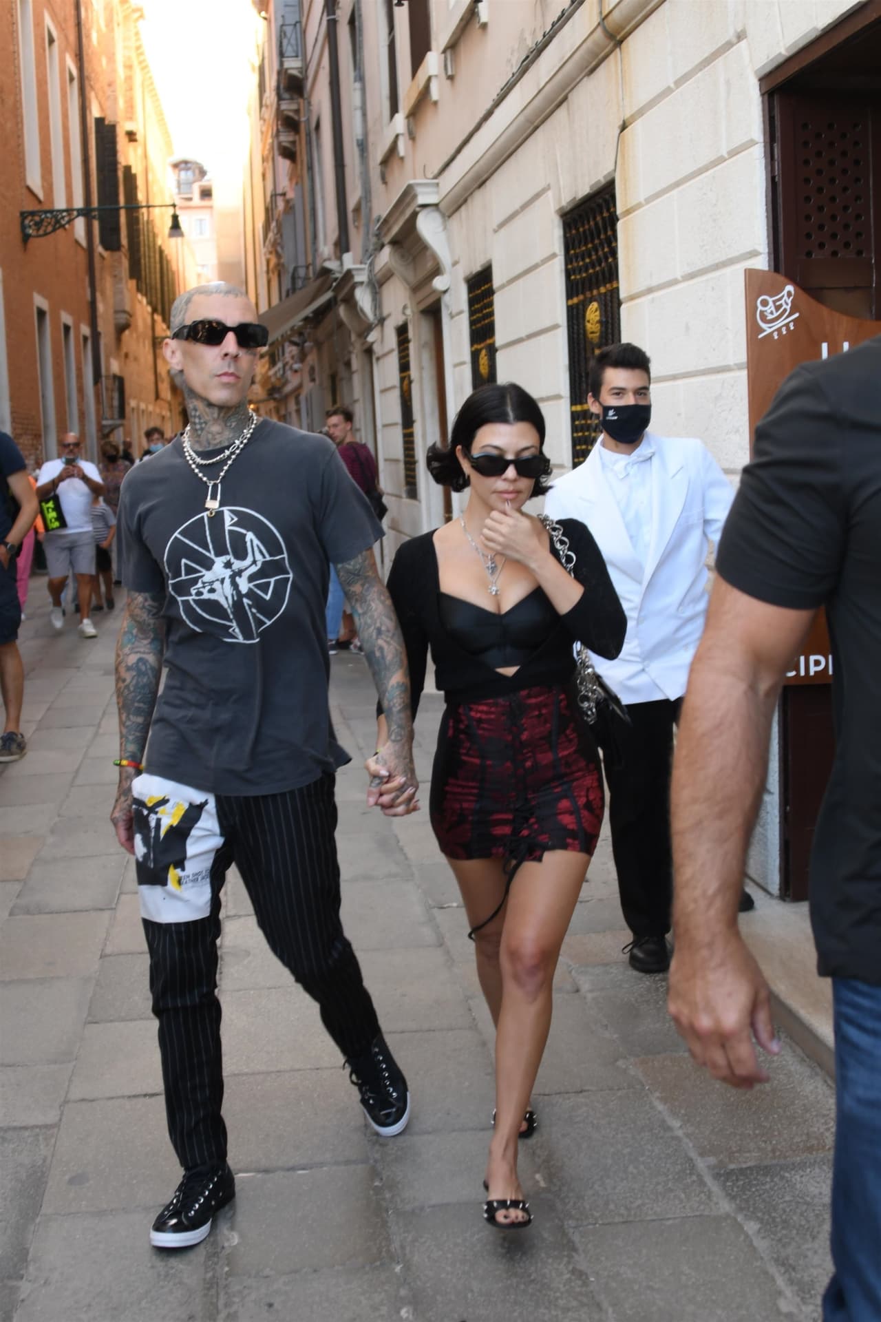 Un cárdigan con manga a tres cuartos negro, un bustier en el mismo color, zapatos mules adornados con picos conformaron el atuendo con el que la socialité caminó de la mano del baterista de Blink 182.