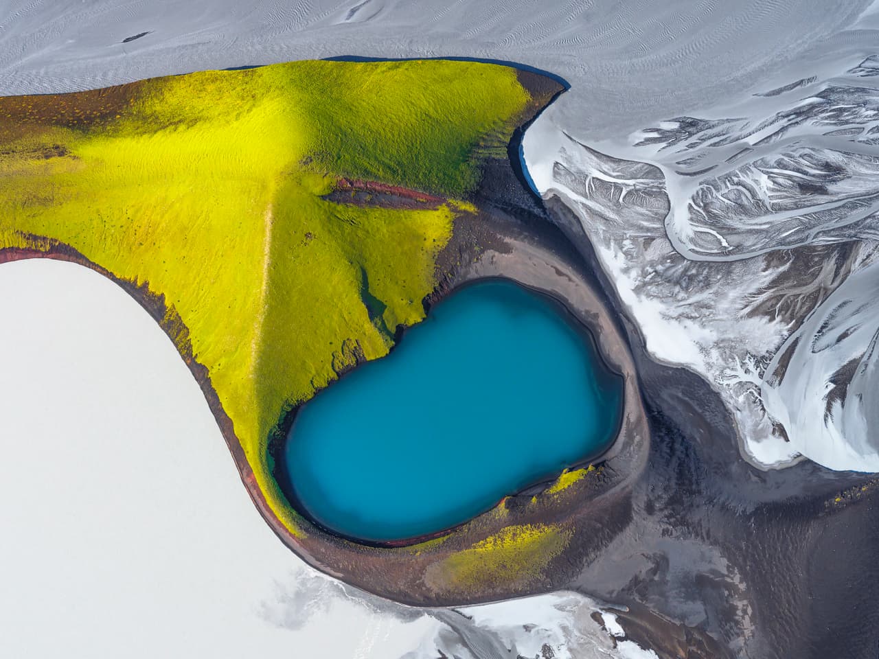 Oasis: el musgo (líquen) en las laderas montañosas contrasta con el azul del lago del cráter y el gris sedimentoso del río Skaftá durante una crecida glaciar en las Tierras Altas del Sur de Islandia.
<br>