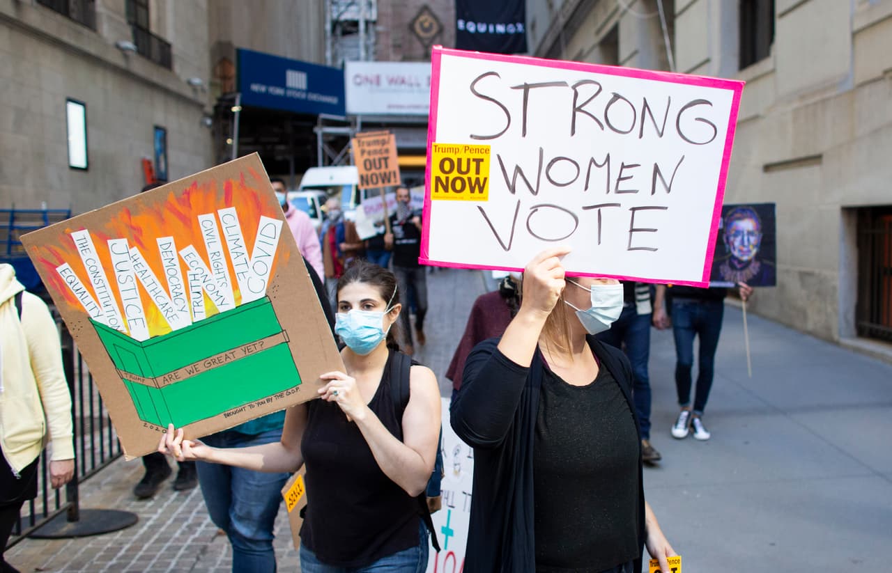 En esta imagen, manifestantes marchan por las calles de Nueva York, con un letrero que dice
<b>"Las mujeres fuertes votan".</b>