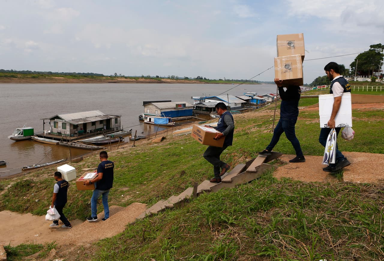 Los trabajadores electorales llevan máquinas de votación electrónica y materiales electorales, que serán llevados en barco a los colegios electorales, un día antes de la segunda vuelta de las elecciones presidenciales del país, en Autazes, estado de Amazonas, Brasil.