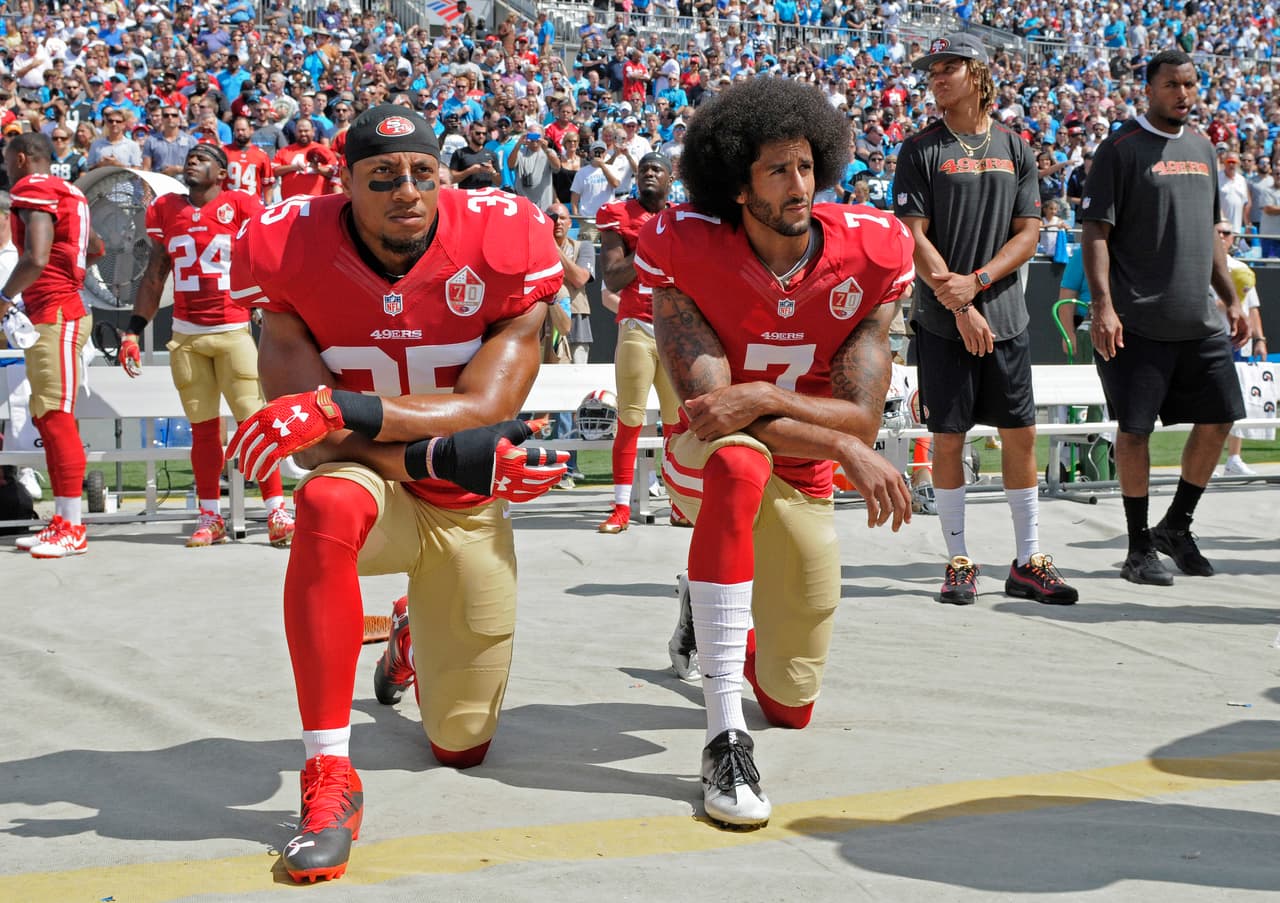 La polémica surgió cuando el jugador Colin Kaepernick (derecha), de los 49ers de San Francisco, se mantuvo arrodillado en 2016 mientras sonaba el himno nacional de EEUU en protesta por la injusticia racial y la brutalidad policial, lo que ha generado opiniones divididas en el país, explicó la agencia EFE.