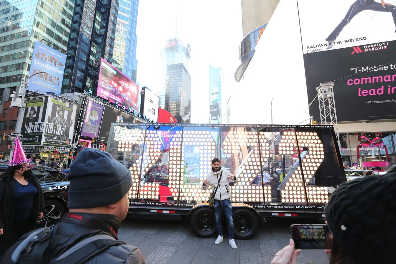 Un hombre se toma una foto frente a un letrero de 2022 en Times Square, Nueva York.