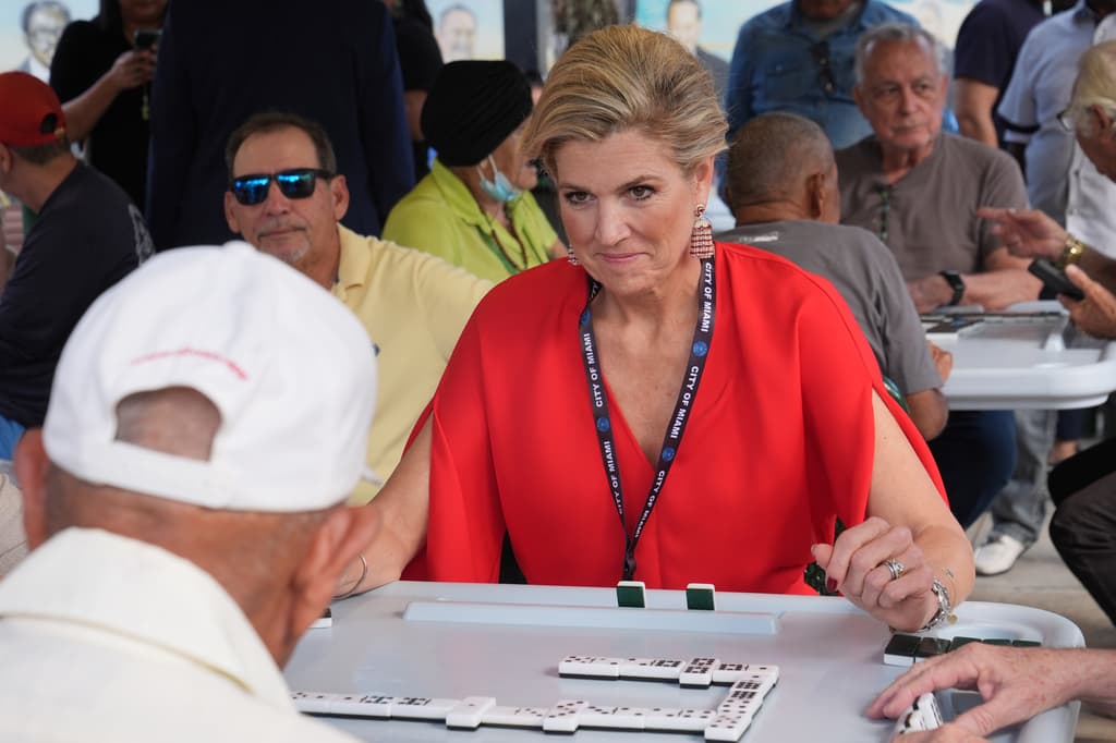 La reina Máxima concentrada jugando dominó.