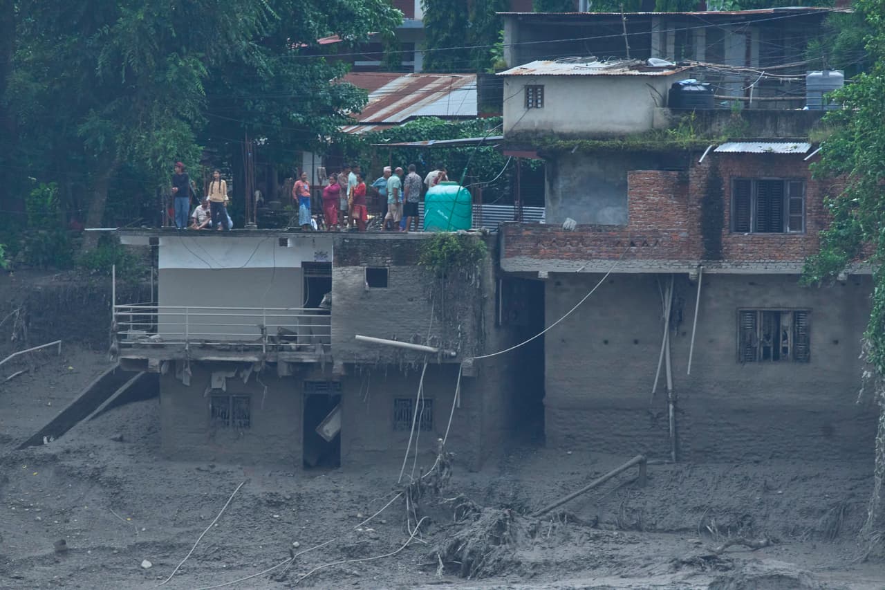 Residentes observan la devastación causada por las inundaciones repentinas a lo largo del río Trishuli.
