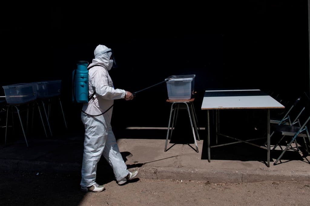 Un trabajador hace labores de desinfección en los centros de votación para el plebiscito de este domingo.