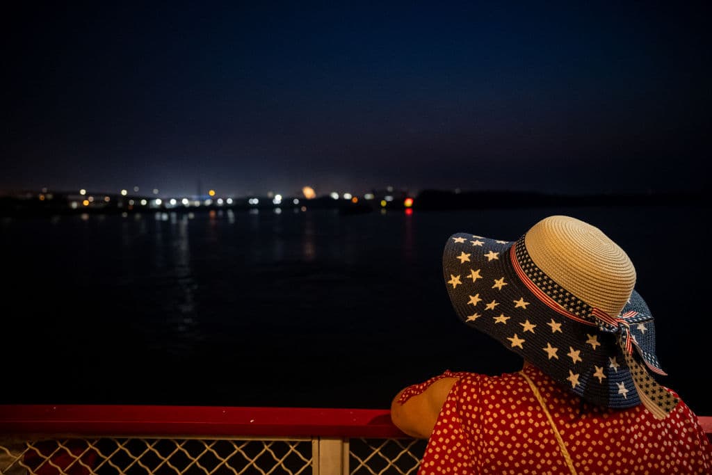 Una mujer con un sombrero decorado con la bandera de EEUU contempla los fuegos artificiales desde el histórico barco de vapor
<b>Belle of Louisville, en Kentucky. </b>
