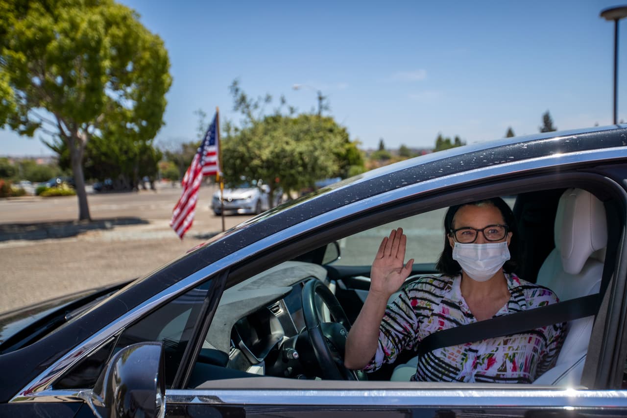 Sofia Wolters, originaria de Alemania, hace su juramento de lealtad para recibir la ciudadanía estadounidense en el auto que va conduciendo por el estacionamiento en un edificio federal en Laguna Niguel, California, el 23 de junio.
